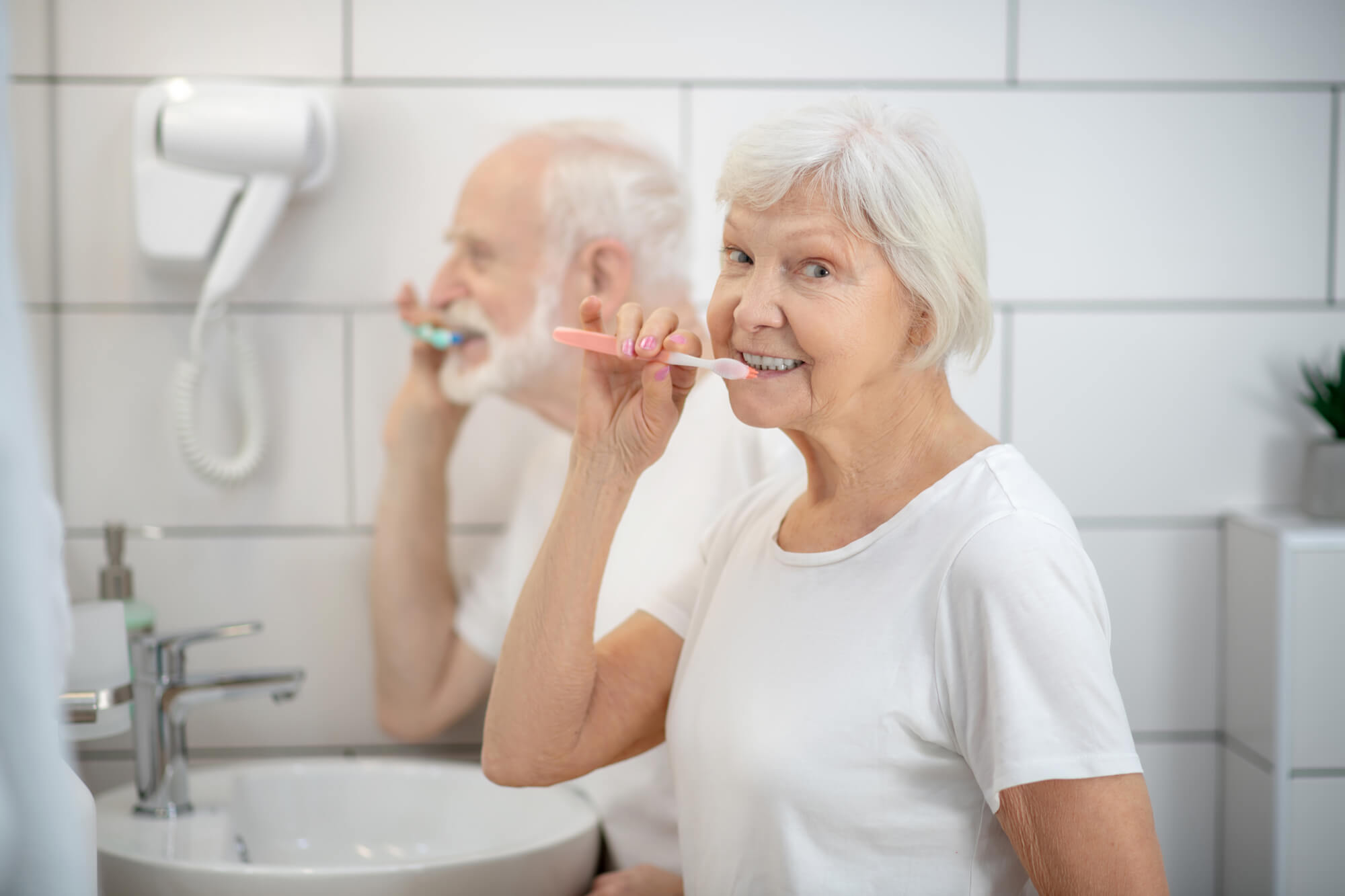 senior couple brushing as advised by an Endodontist in Miami